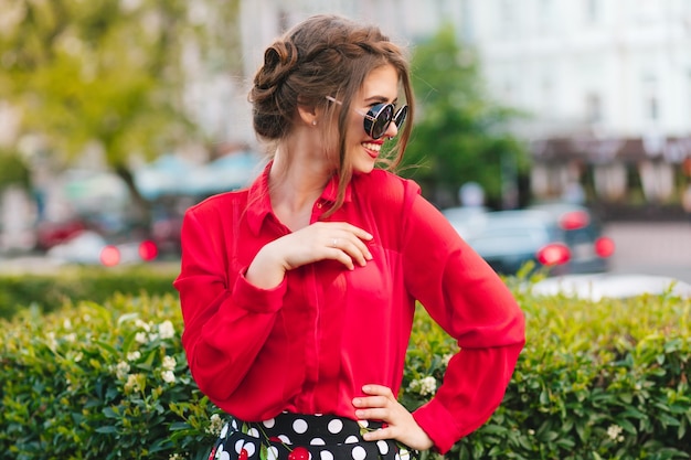 Free Photo Portrait Of Pretty Girl In Sunglasses Posing To The Camera In Park She Wears Red