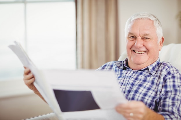 Premium Photo | Portrait of senior man sitting on sofa and reading a ...