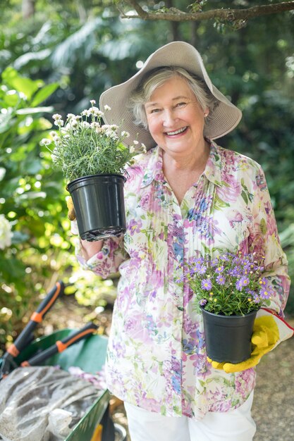 Premium Photo Portrait Of Senior Woman Holding Potted Plants