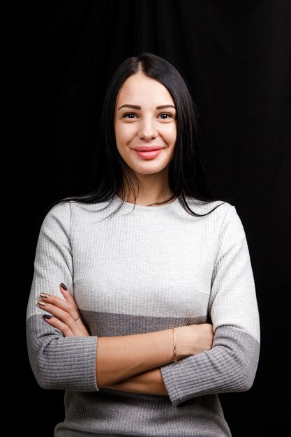 Premium Photo Portrait Of Serious Beautiful Female With Black Hair Has Minimal Makeup Looks Calmly At Camera Wears White Jumper Stands Against Black Space Being Deep In Thoughts