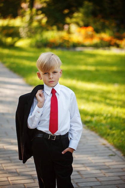 Portrait serious little boy wearing business suit and red tie on ...