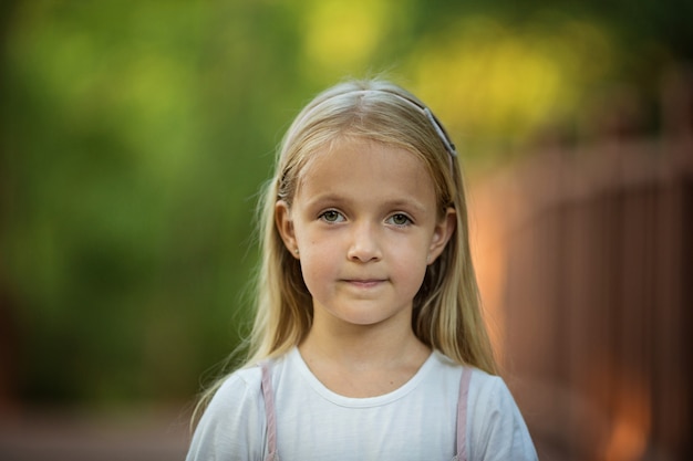 Portrait Of Serious Little Girl With Blonde Hair Outdoor Premium