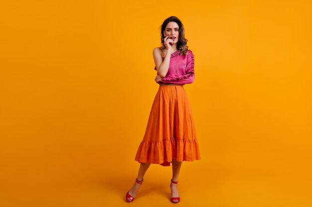 Portrait of serious woman wears long orange skirt Free Photo