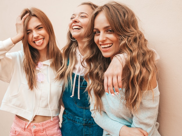 Portrait of sexy carefree women posing on the street near wall.positive models having fun.hugging Free Photo
