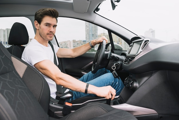 Portrait of smart young man sitting inside the car driving Photo | Free
