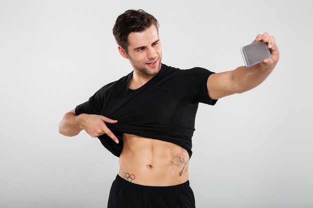 Free Photo Portrait Of A Smiling Charming Man Pulling His Shirt Up