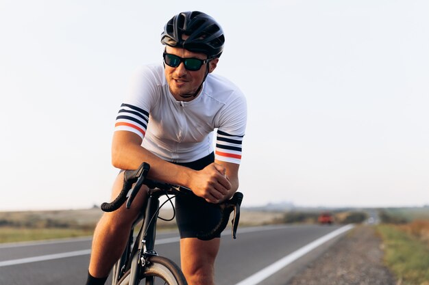 Premium Photo | Portrait of smiling cyclist in sitting on black bike ...