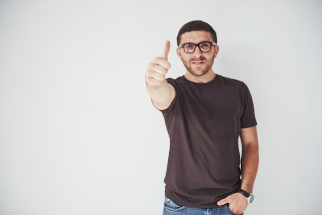 Premium Photo | Portrait of a smiling man in glasses showing thumb up ...