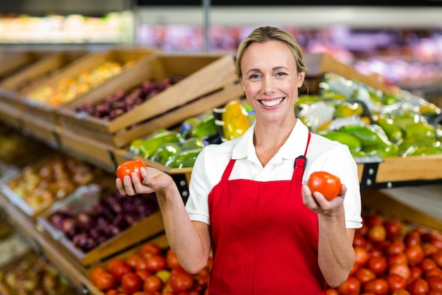 Premium Photo | Portrait of smiling seller holding tomatoes