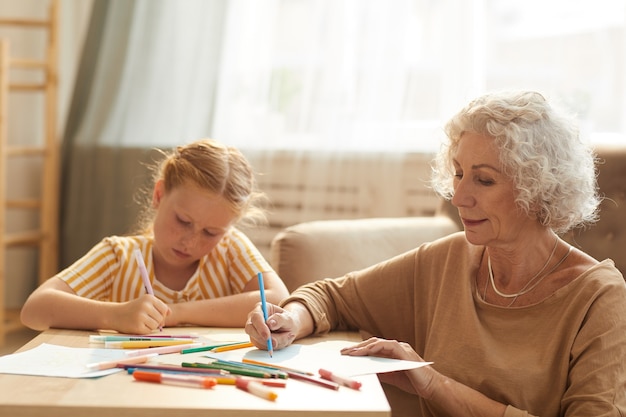 Premium Photo | Portrait of smiling senior woman babysitting cute red ...