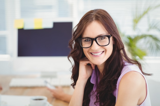 Portrait Of Smiling Woman Wearing Eyeglasses At Des