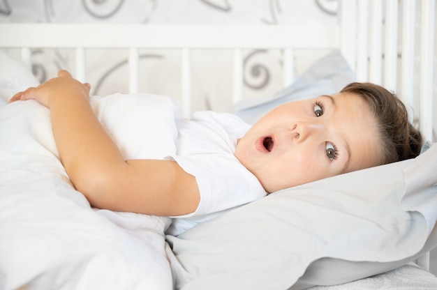 Premium Photo | Portrait of a surprised cute boy in bed on white bed ...