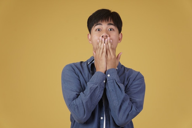 Premium Photo Portrait Of Surprised Excited Young Asian Man Dressed Casually With Hands Covering Mouth Isolated