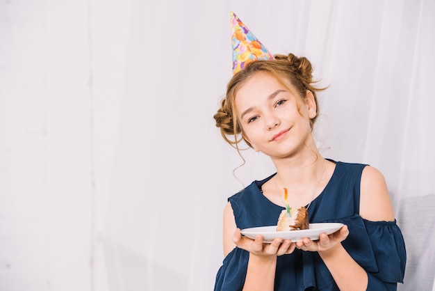 Free Photo | Portrait of a teenage girl holding slice of cake on white ...