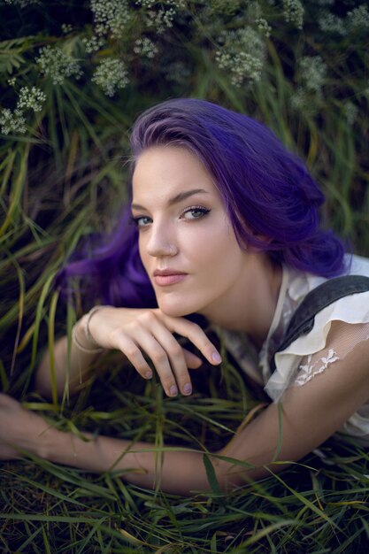 Lav aftensmad lobby permeabilitet Premium Photo | Portrait of a teenage girl with purple hair and an earring  in her nose lying in the grass in nature