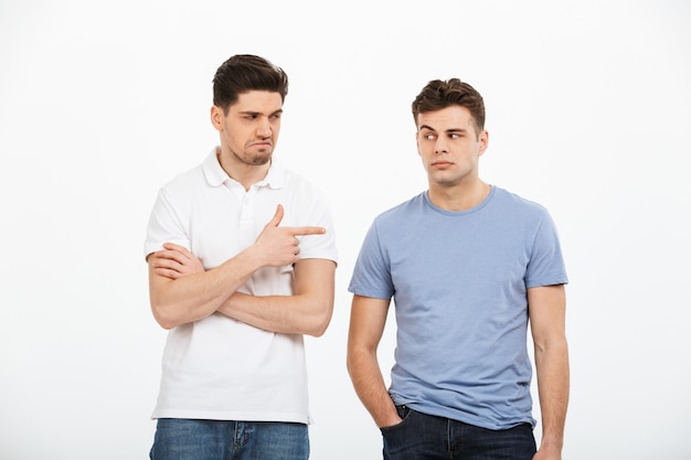 Premium Photo | Portrait of two disappointed young men pointing finger