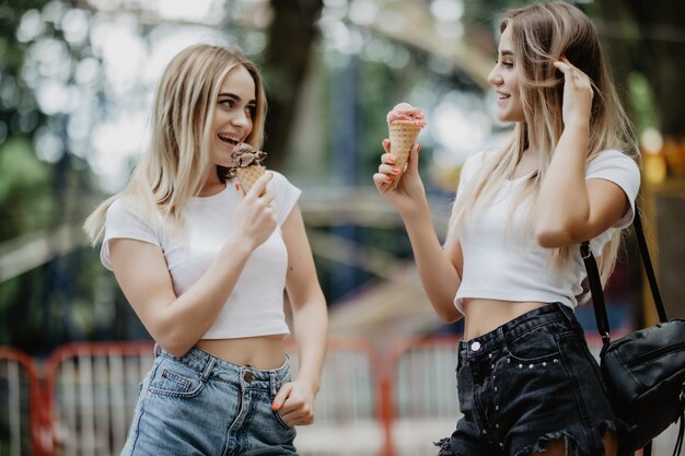 Portrait Of Two Girls In Glasses Licking Ice Cream In City Park Free
