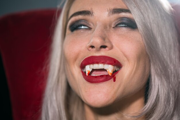 Premium Photo  Portrait of a vampire woman with a bloody mouth and teeth fangs celebrating a 