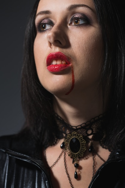 Premium Photo  Portrait of a vampire woman with a bloody mouth and teeth fangs celebrating a 