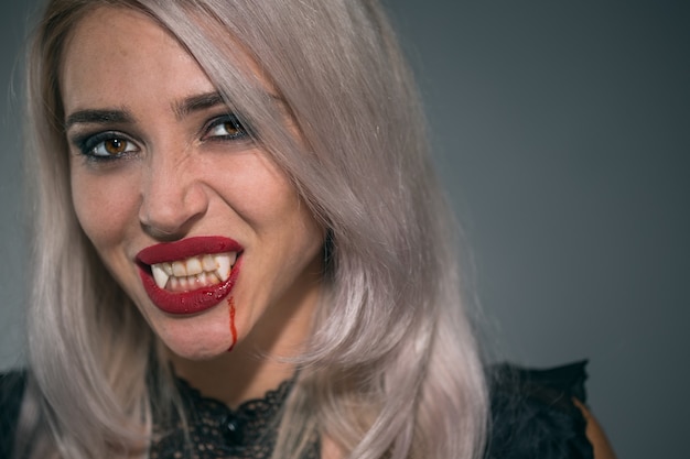 Premium Photo  Portrait of a vampire woman with a bloody mouth and teeth fangs celebrating a 