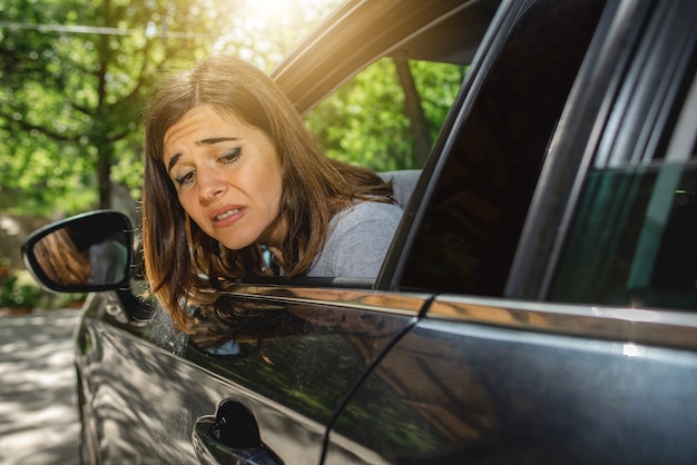 Premium Photo Portrait Of Woman Inside Car Looking Out The Window With Worried Face Maybe Because Scratched Car During Parking Or Accident On Back Side