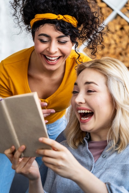 Free Photo Portrait Of Women Laughing While Reading Book