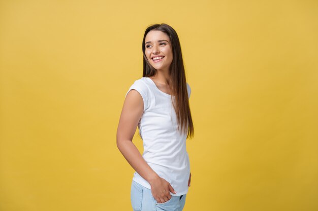 Portrait young beautiful caucasian girl with an white shirt laughing over yellow background. Premium Photo