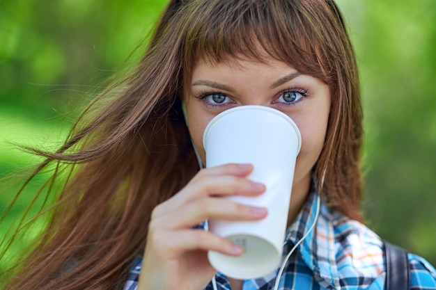 紙コップでコーヒーを飲む肖像若い美しい女性 プレミアム写真