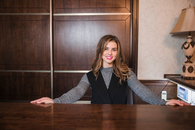 Portrait of a young friendly receptionist standing at her desk Photo ...