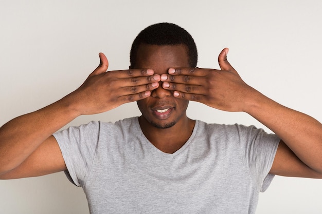 Premium Photo | Portrait of young happy black man covering eyes with ...