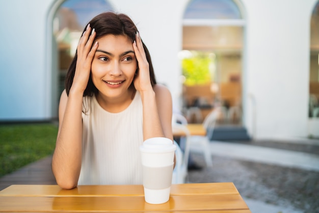 Portrait Of Young Latin Woman Enjoying And Drinking A Cup Of Coffee