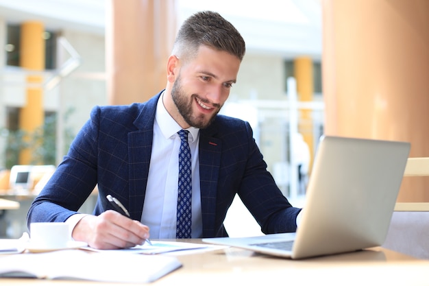 Premium Photo | Portrait of young man sitting at his desk in the office.