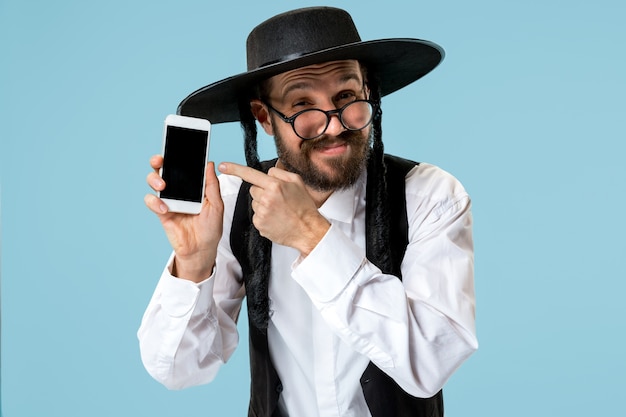 Portrait of a young orthodox jewish man with mobile phone at studio. Free Photo