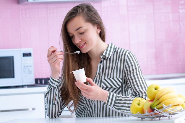 Premium Photo | Portrait of a young, smiling, happy woman eating yogurt