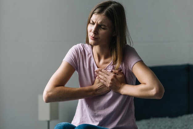 Portrait of a young woman suffering from chest pain | Free Photo