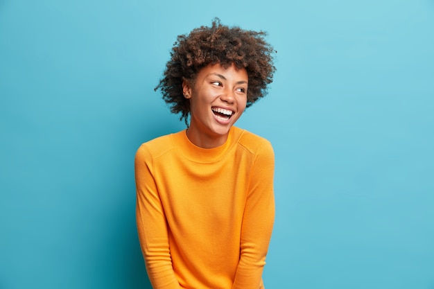 Premium Photo | Positive beautiful young woman laughs poisitively looks ...