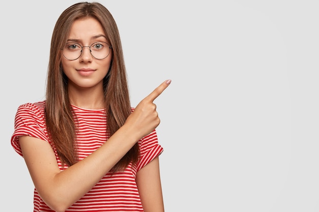 ポジティブな嬉しい女性は、プロモーションコンテンツの空白のコピースペースを示します。 無料写真