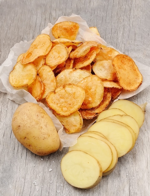 Premium Photo | Potato chips closeup on wooden tables.