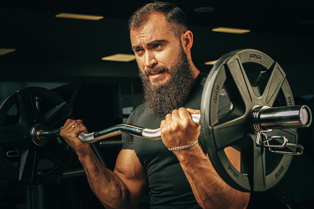 Premium Photo | Powerlifter with strong arms lifting barbell in a gym