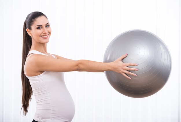 Premium Photo | Pregnant girl holds gymnastic ball.