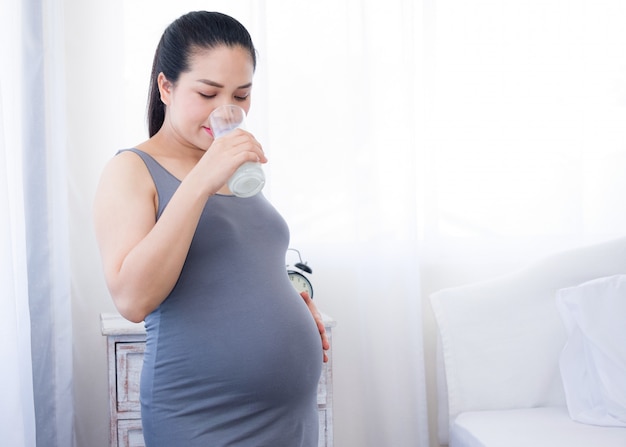 Pregnant woman drinking milk on clear background. health care in pregnancy. Premium Photo