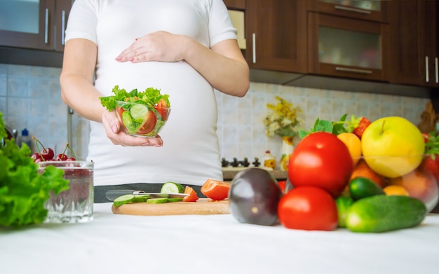 Premium Photo | A pregnant woman eats vegetables and fruits