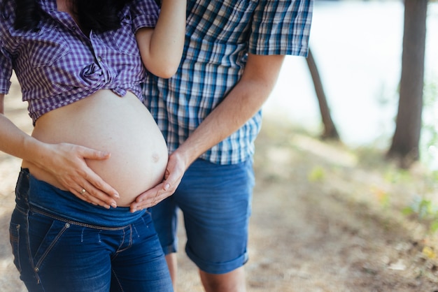 Pregnant woman holding her hands on stomach | Premium Photo