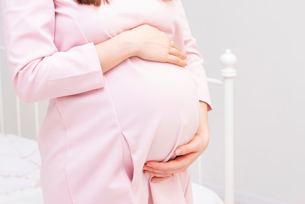 Беременная женщина на белом фоне