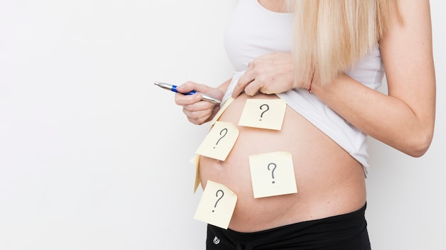 Pregnant woman with notes on body Free Photo