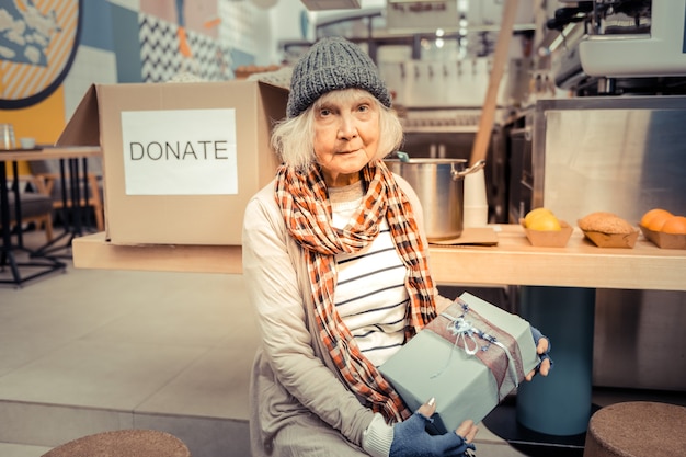 Premium Photo Present For Me Nice Homeless Woman Holding A Gift Box While Looking At You