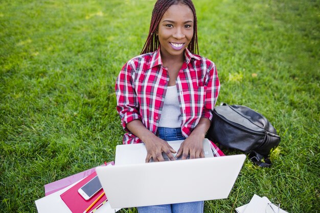 Pretty black student typing on laptop Photo | Free Download