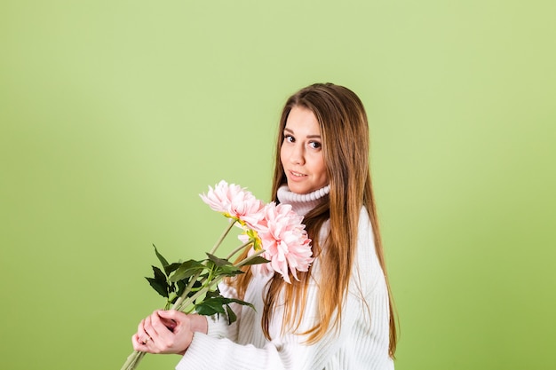 笑顔でピンクの花の花束を保持しているカジュアルな白いセーター孤立した ロマンチックな外観のかなりヨーロッパの女性 無料の写真