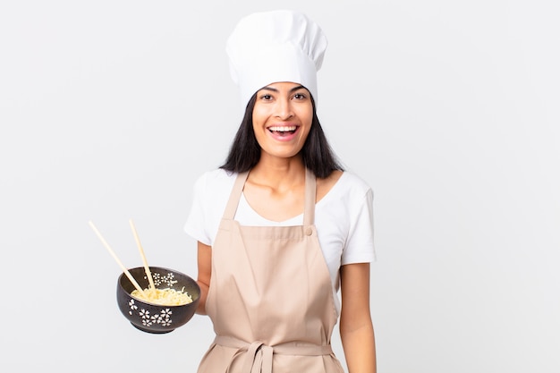 Premium Photo Pretty Hispanic Chef Woman Looking Happy And Pleasantly Surprised And Holding A Noodle Bowl