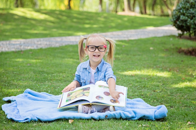 A Pretty Little Blonde Girl With Blonde Hair And Reading Glasses